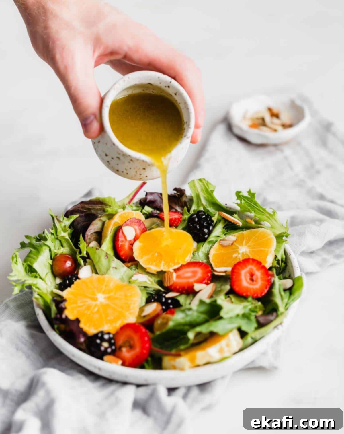 Καλοκαιρινή Σαλάτα με Εσπεριδοειδή 4 Vinaigrette εσπεριδοειδών χύνεται πάνω από μια σαλάτα με εσπεριδοειδή.
