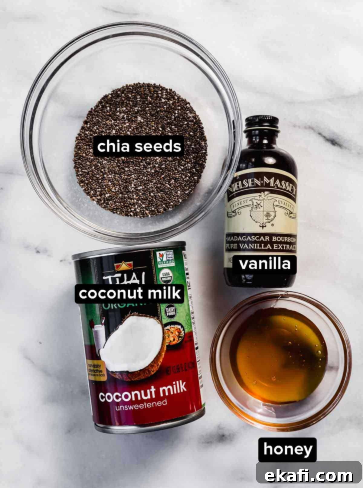 Tropical Chia Pudding Bliss 3 Coconut chia pudding ingredients on a white marble background: chia seeds, vanilla, coconut milk, and honey.