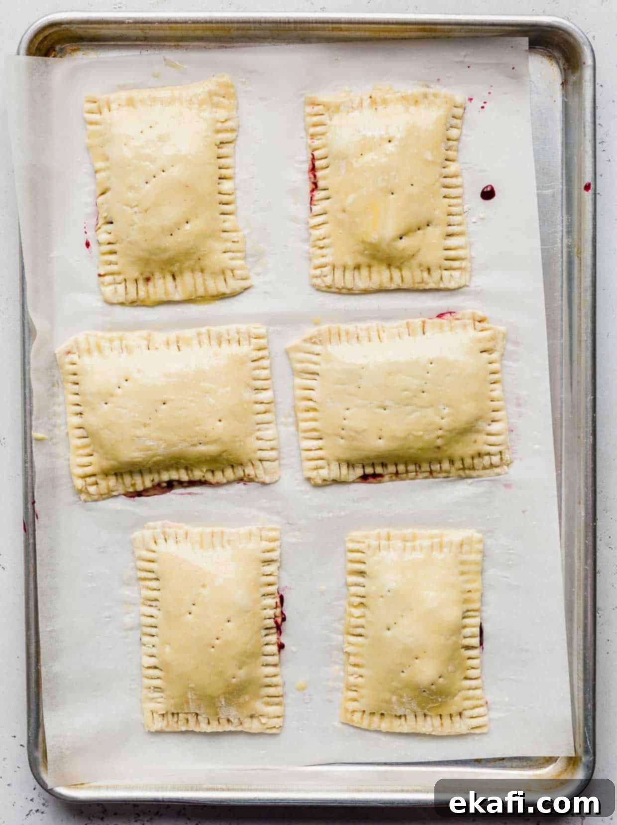 Σπιτικά Στρούντελ 7 Άψητα σπιτικά toaster strudels γεμισμένα με σπιτική μαρμελάδα σε λευκό αντικολλητικό χαρτί.