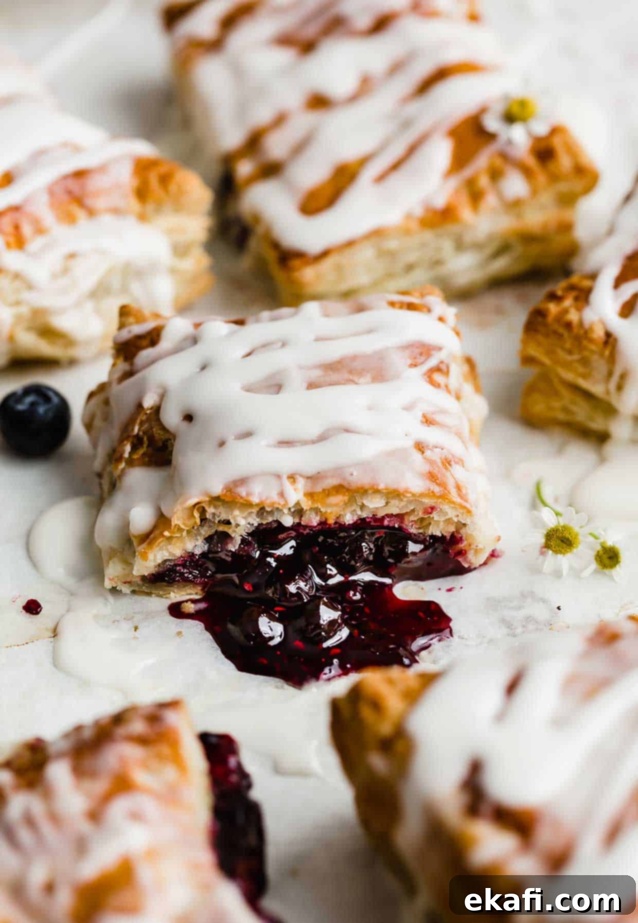 Σπιτικά Στρούντελ 10 Ένα σπιτικό Toaster Strudel που έχει κοπεί στη μέση και έχει τη μαρμελάδα τριπλών μούρων να χύνεται στο λευκό τραπέζι.