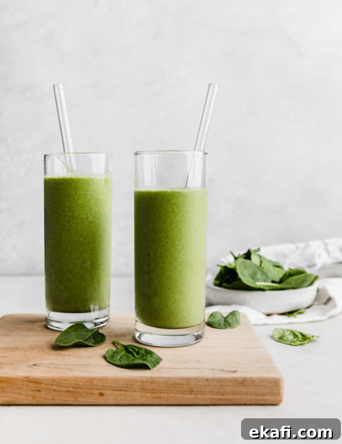 Πράσινο Πρωτεϊνούχο Smoothie 2 Δύο ψηλά ποτήρια γεμάτα Πράσινο Smoothie Πρωτεΐνης μπροστά σε λευκό φόντο.