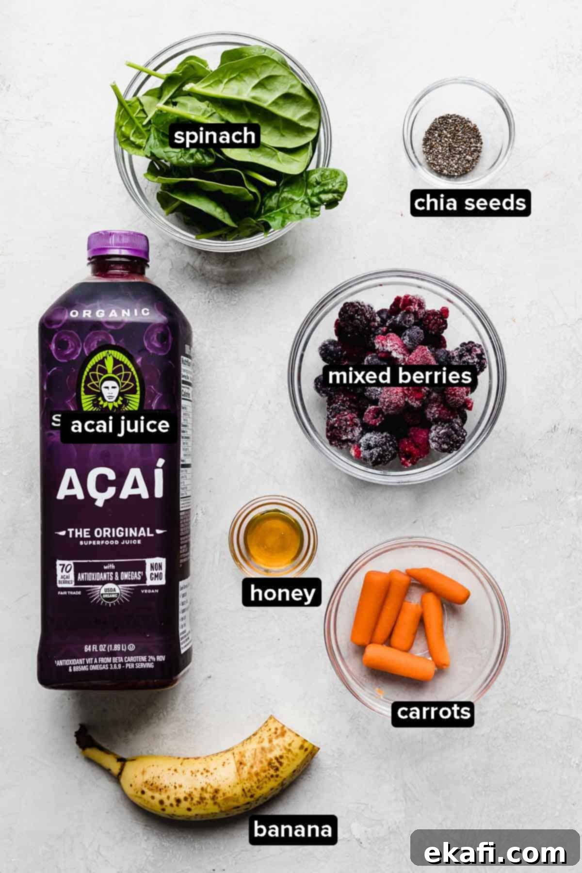 Ασάι Σμούθι 3 Συστατικά Acai Smoothie σε λευκό φόντο: καρότα, ανάμεικτα μούρα, σπανάκι, χυμός açaí, σπόροι chia και μέλι.