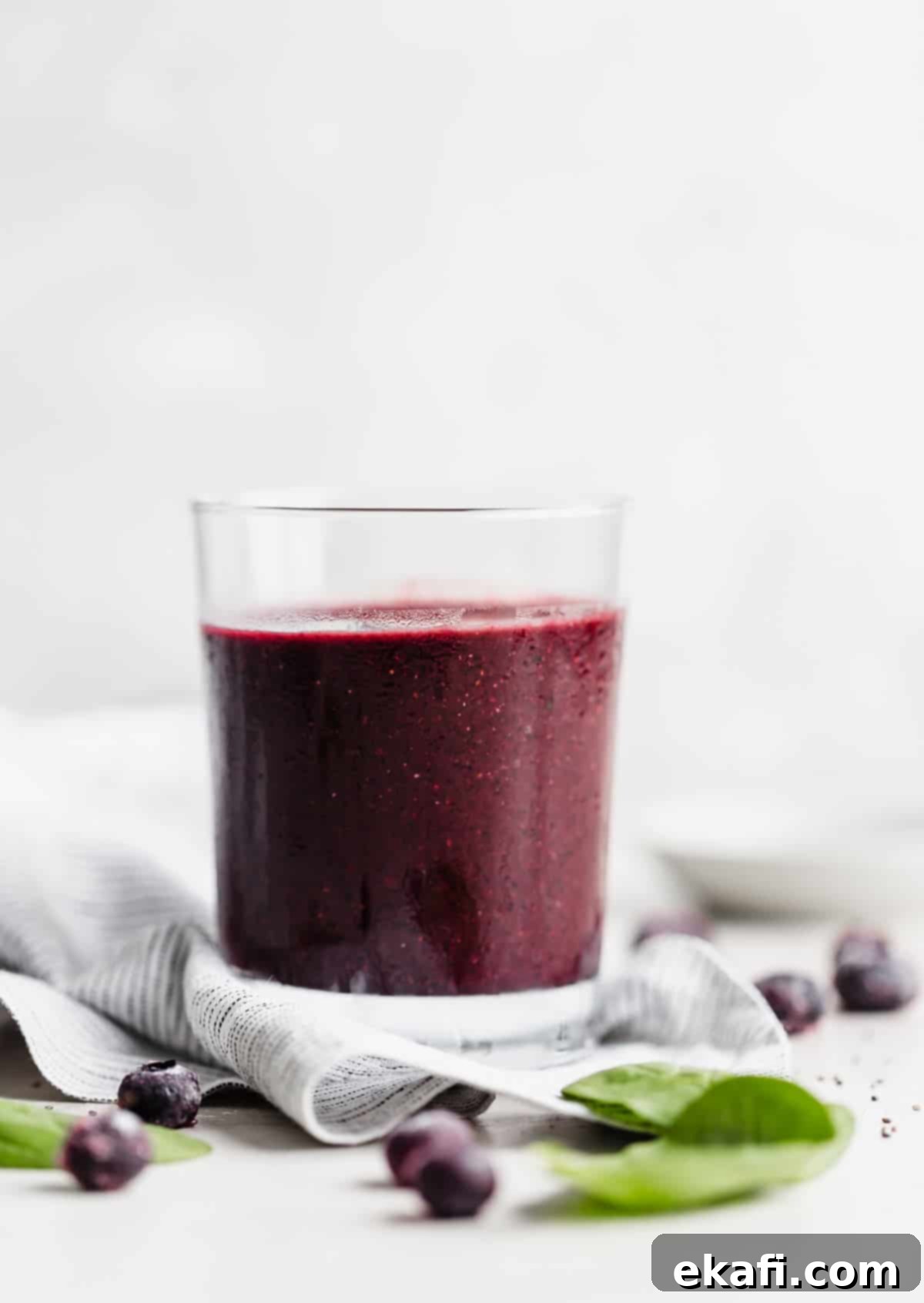 Ασάι Σμούθι 7 Σκούρο μωβ Acai Smoothie σε διάφανο ποτήρι σε λευκό φόντο.