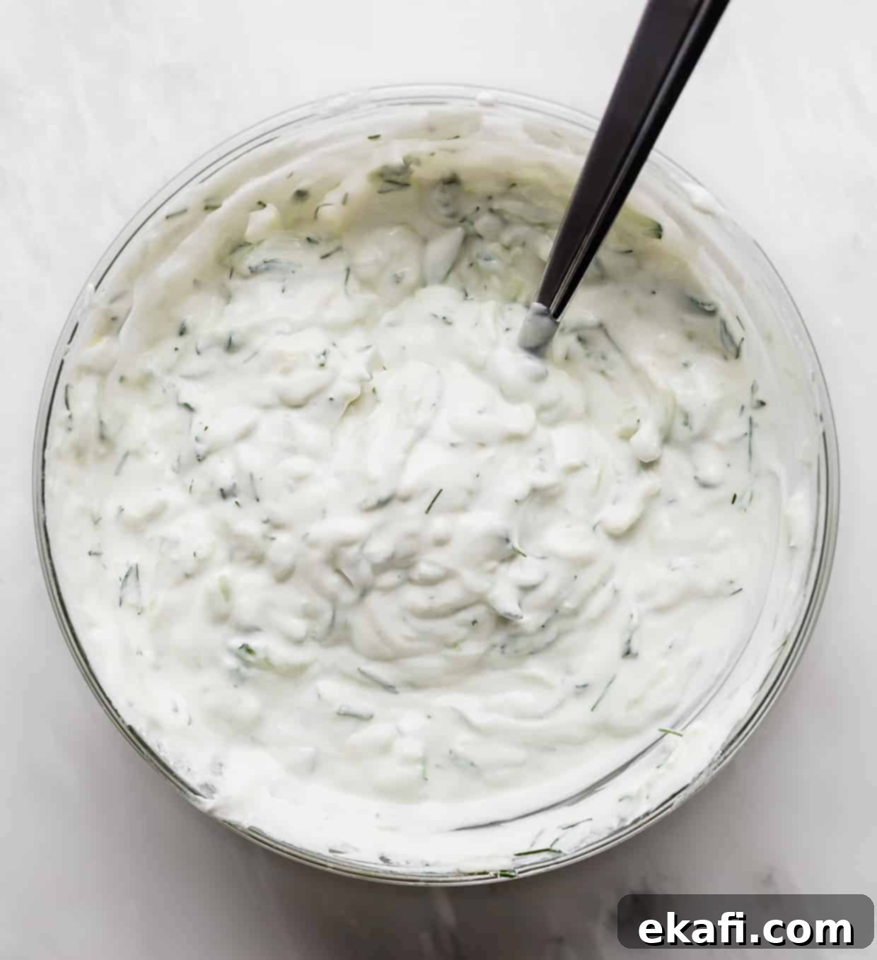 Authentic Tzatziki Recipe 5 A bowl of Tzatziki sauce on a white background.