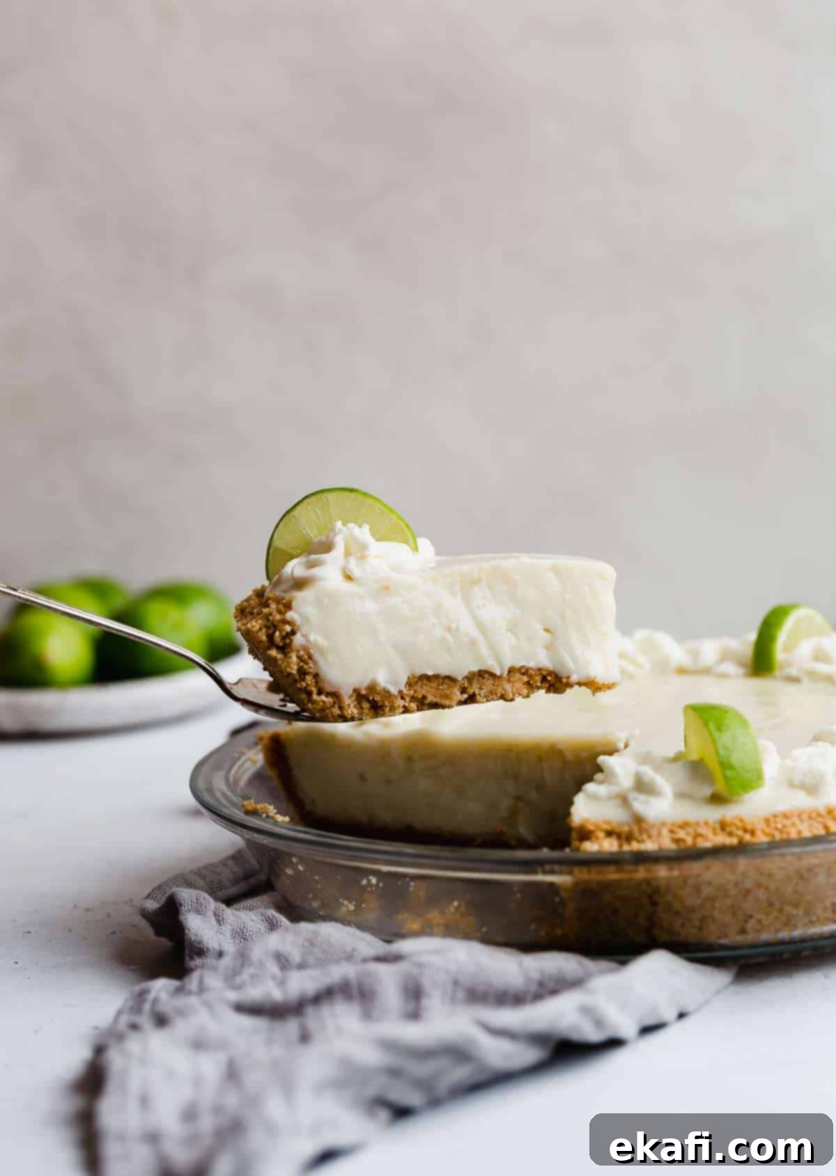 Velvety Key Lime Indulgence 6 A perfectly balanced slice of creamy sour cream Key Lime Pie resting on a pie server, showcasing its smooth texture and golden graham cracker crust.