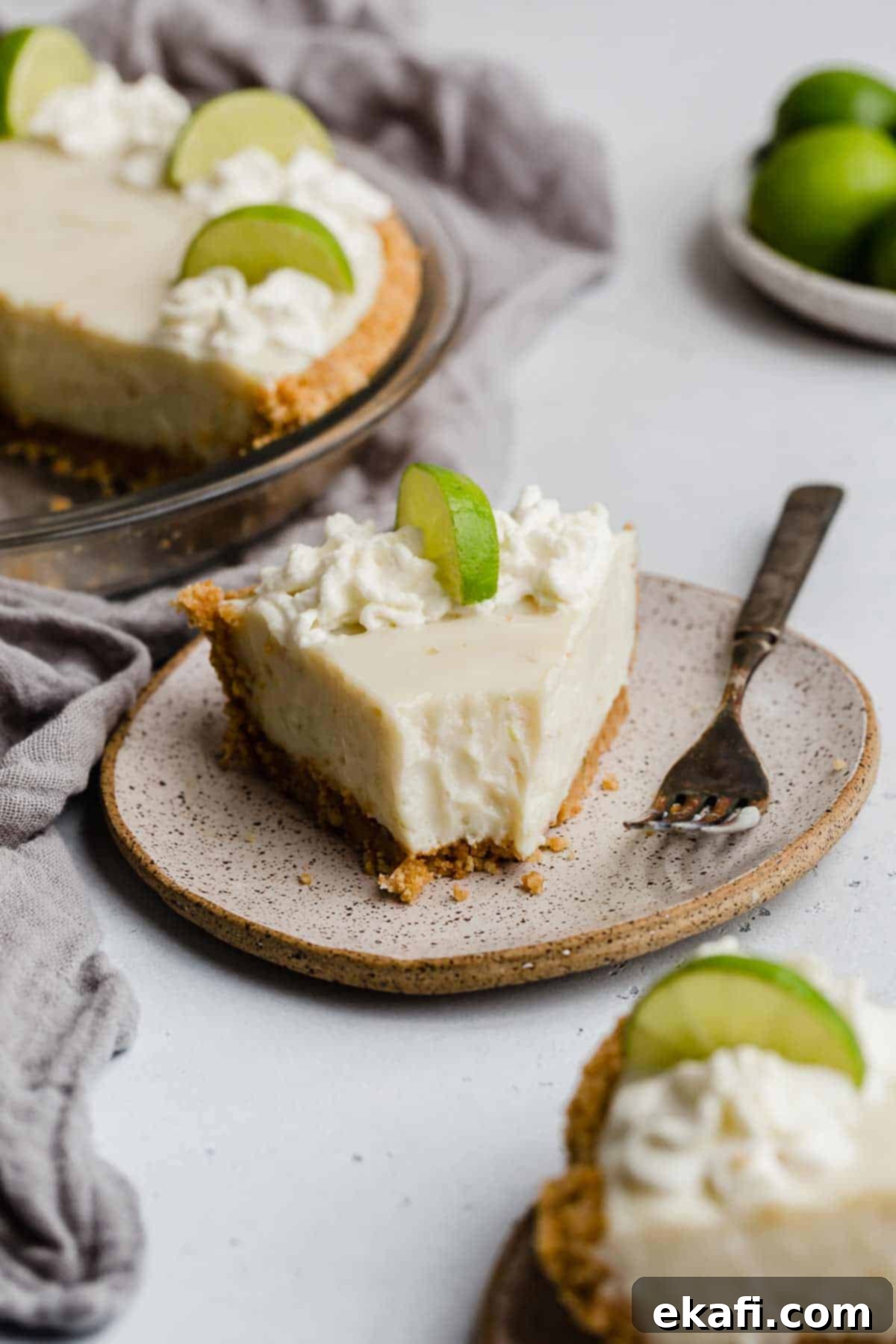 Velvety Key Lime Indulgence 7 A generous slice of easy Key Lime Pie, creamy and tangy, served on a white plate ready to be enjoyed.