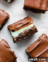 BYU Μπράουνις Μέντας 9 Ένα BYU Mint Brownie κομμένο σε τετράγωνο που δείχνει τη στρώση brownie, το γλάσο μέντας και τη στρώση σοκολατένιου frosting.