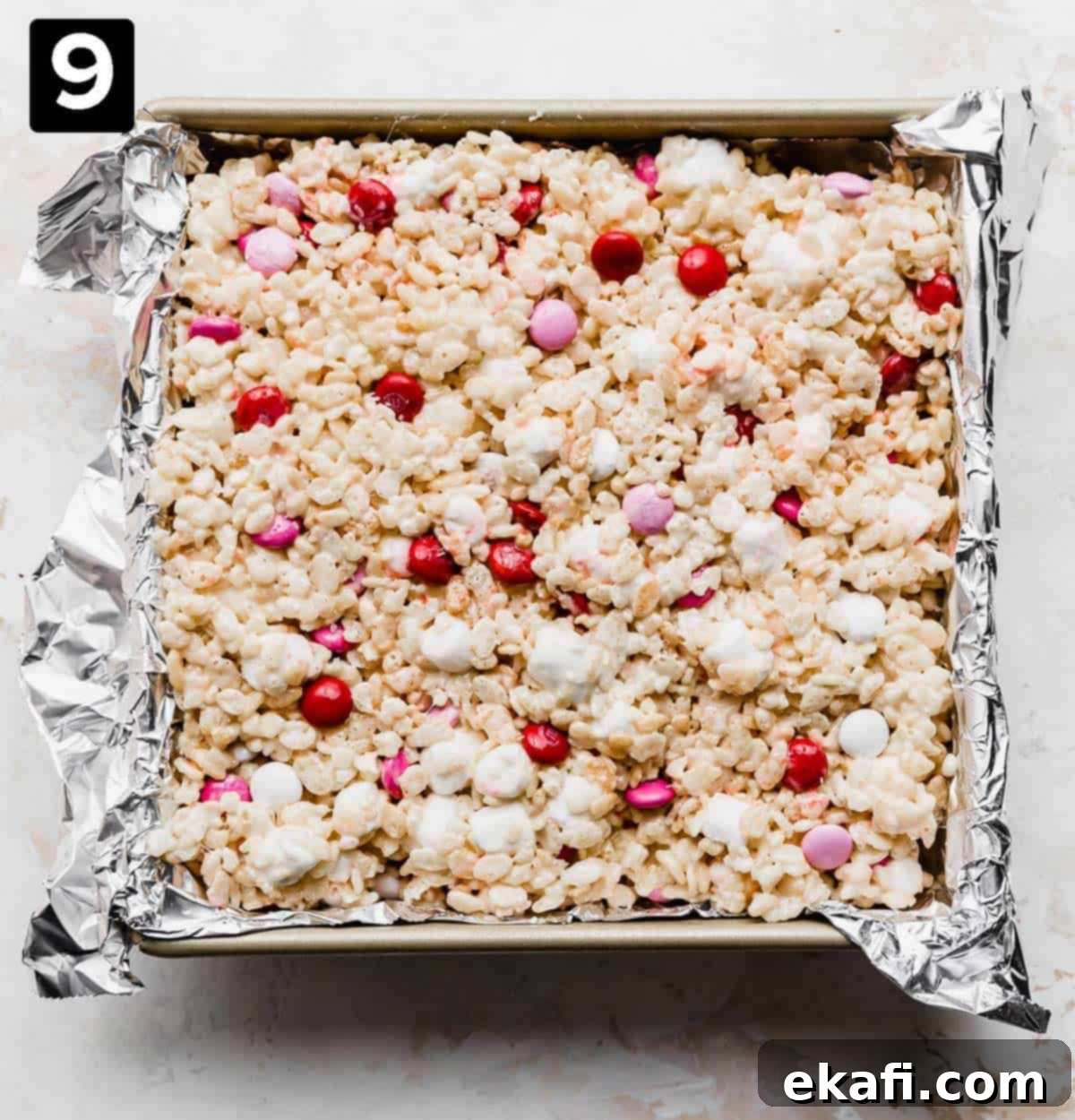 Colorful M and M Rice Krispie Bars 6 A square pan with M&M Rice Krispie treats lightly pressed into it.