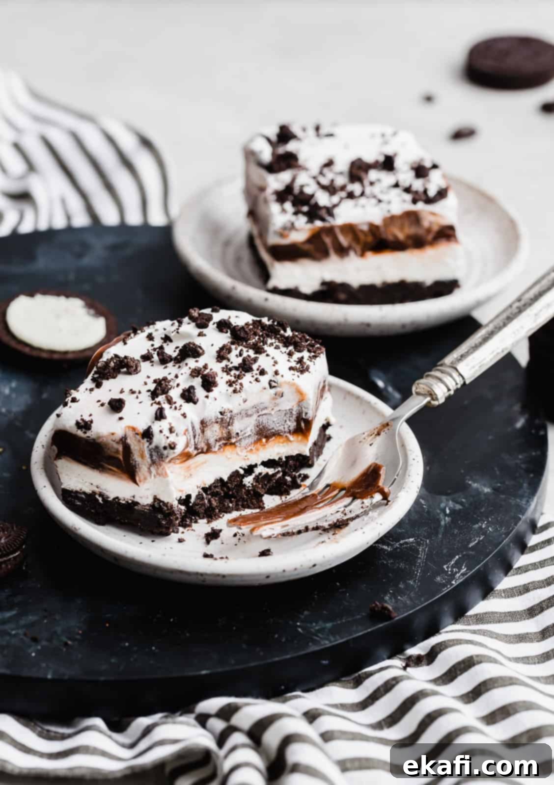 Effortless Oreo Magic 9 A square slice of Oreo Dessert and fork on a white plate.