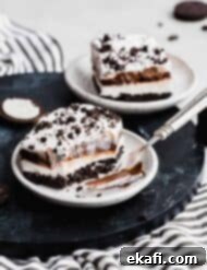 Effortless Oreo Magic 10 A square slice of Oreo Dessert and fork on a white plate.