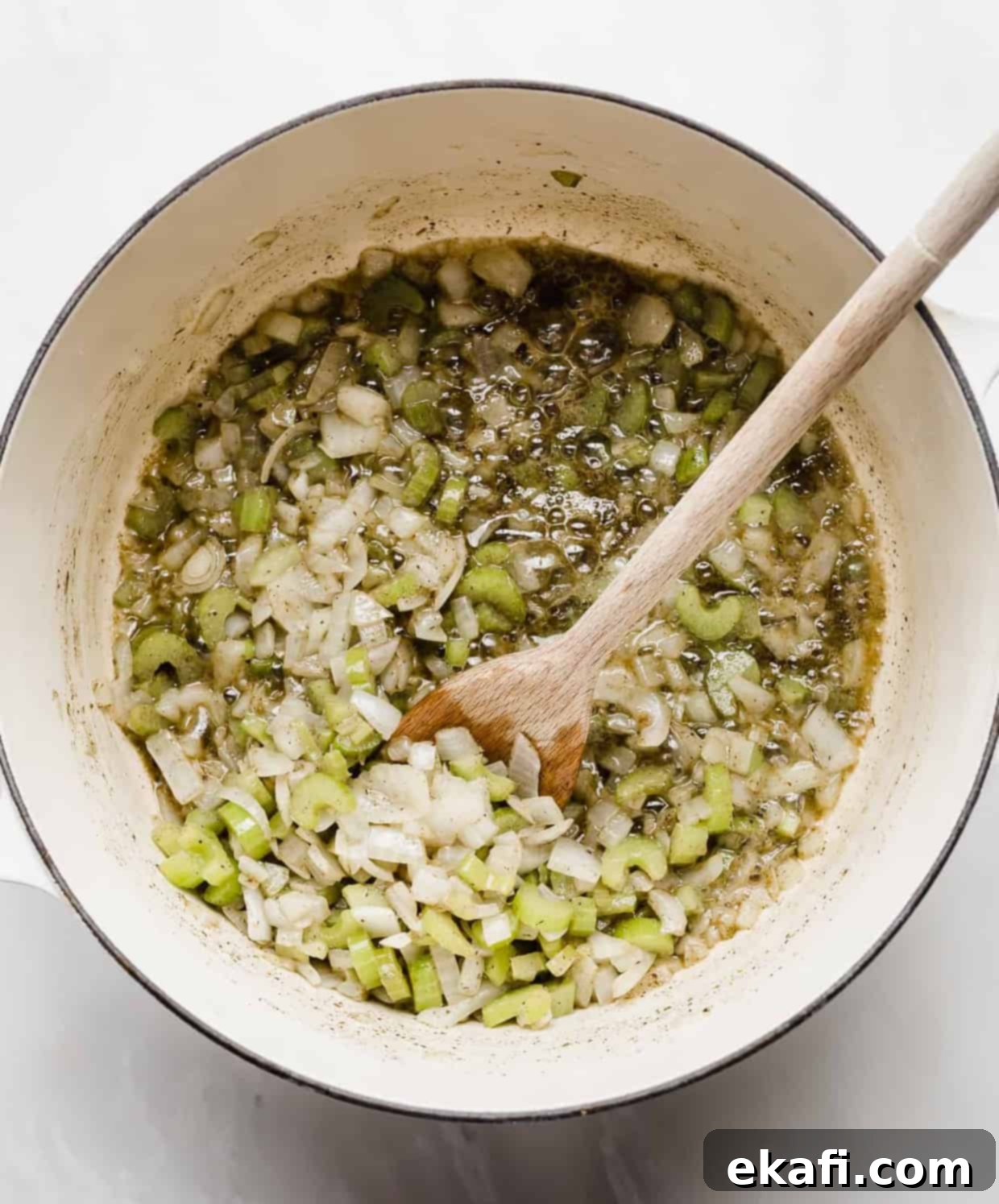 The Ultimate Thanksgiving Stuffing 4 A dutch oven with chopped onion and celery cooking in melted butter.