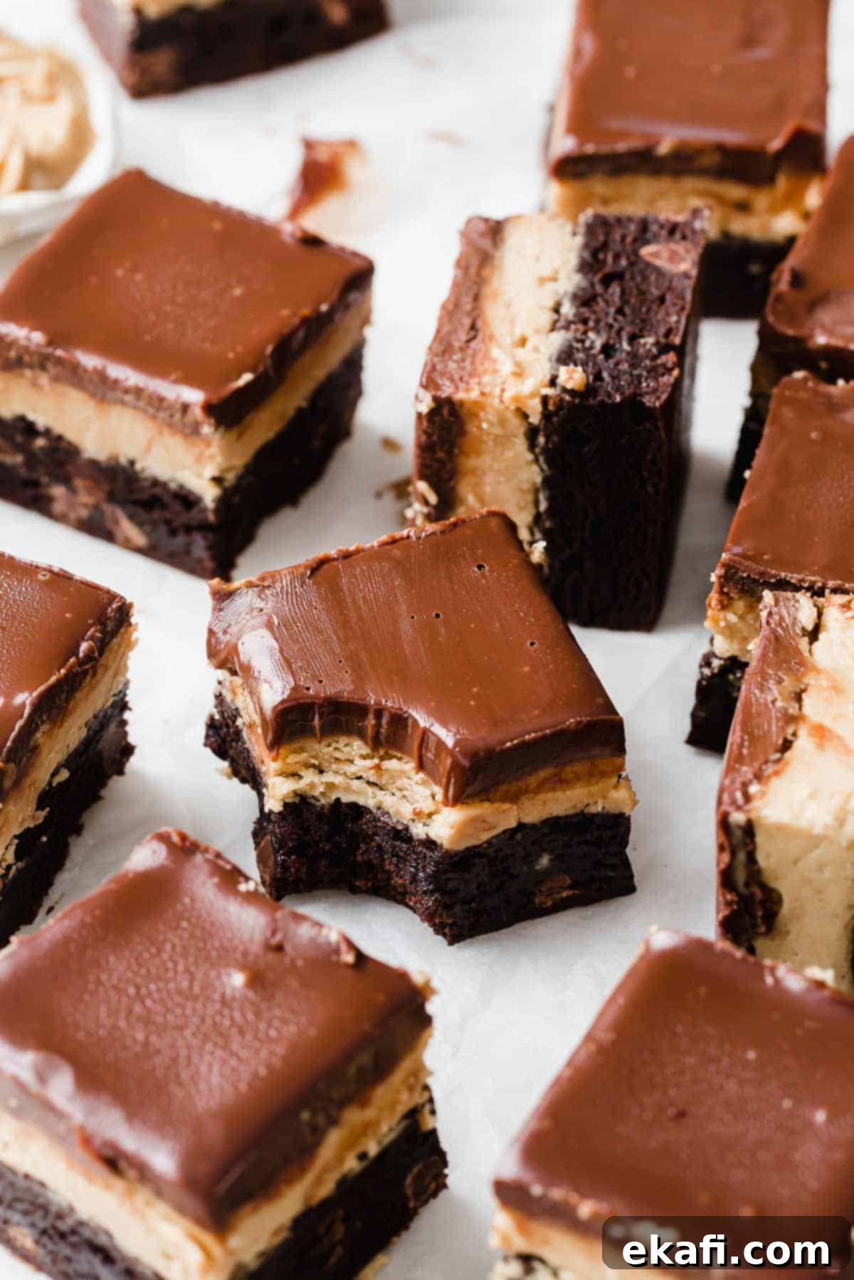 Ultimate Buckeye Brownies 2 A Buckeye Brownie on a white background with a bite taken out of it, showing the distinct layers.