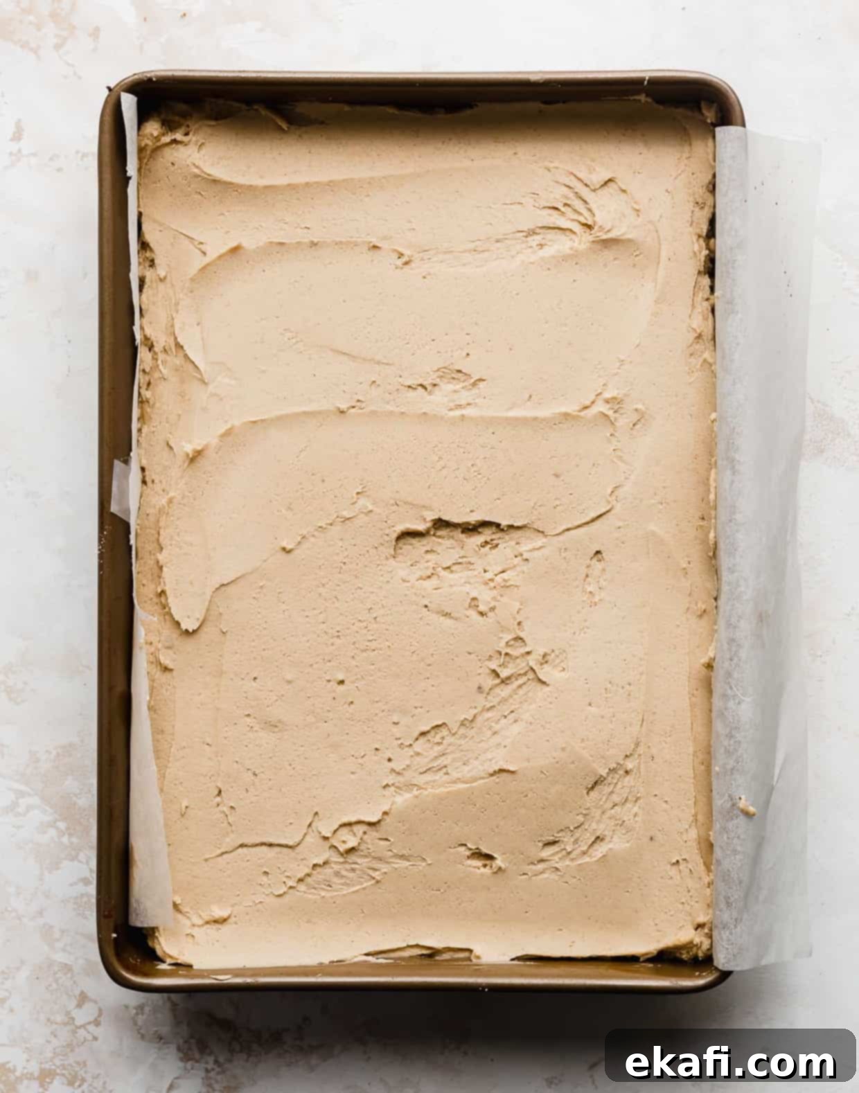 Ultimate Buckeye Brownies 6 Peanut butter buckeye filling spread evenly over a pan of brownies, demonstrating a smooth layer.