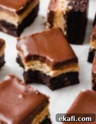 Ultimate Buckeye Brownies 9 Buckeye Brownies cut into squares, with a bite taken out of one brownie, ready for a recipe card.