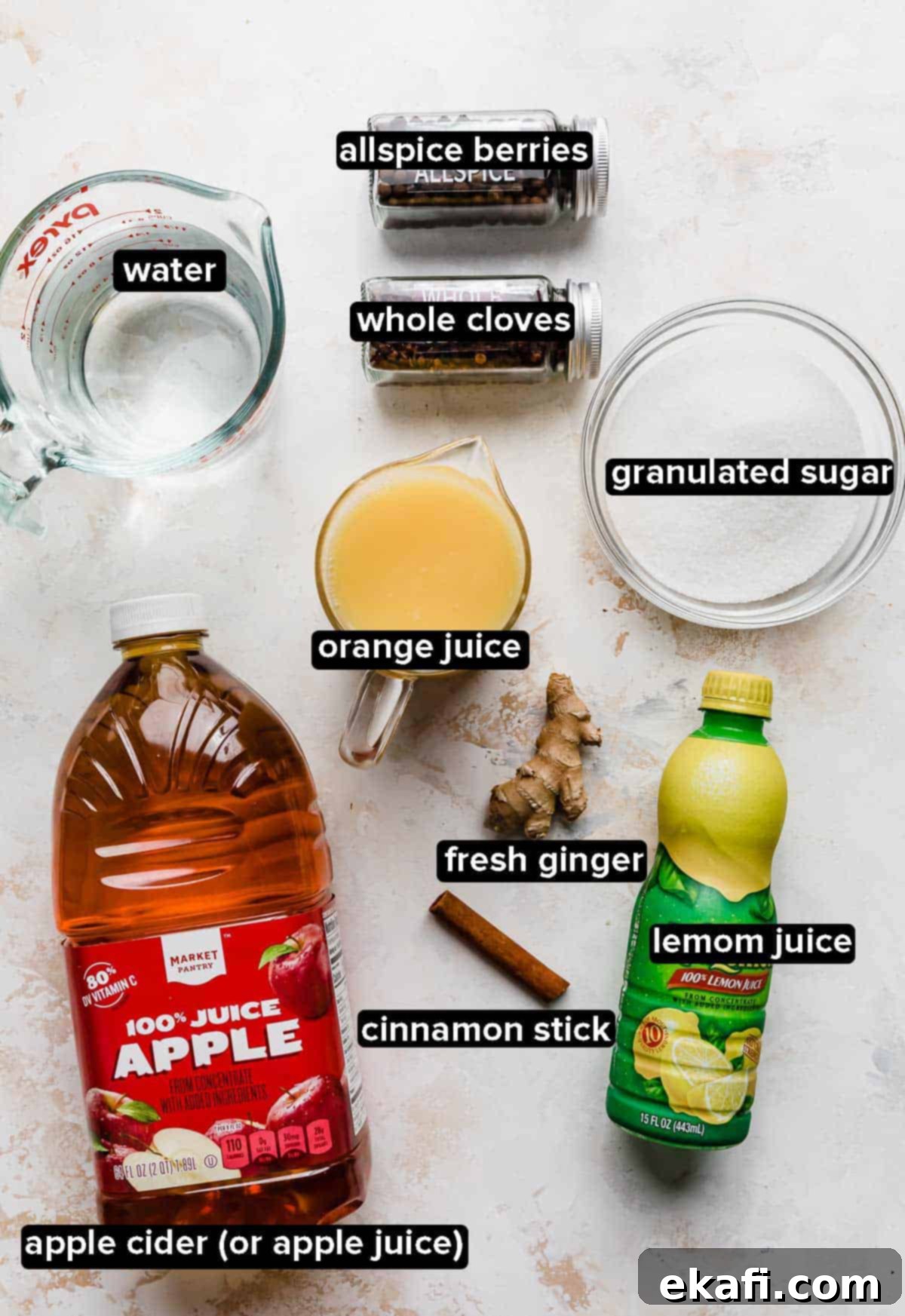 Warm Yuletide Brew 3 Homemade wassail ingredients on a white textured background: apple cider or apple juice, orange juice, lemon juice, water, sugar, and various whole spices.
