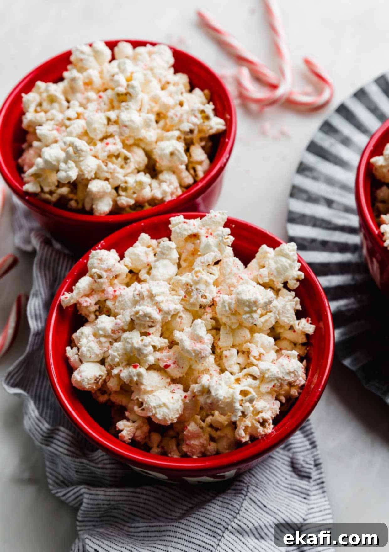 Ζαχαρομπαστουνένιο Ποπ κορν 5 Candy Cane Popcorn σε κόκκινο μπολ με candy canes στο φόντο.