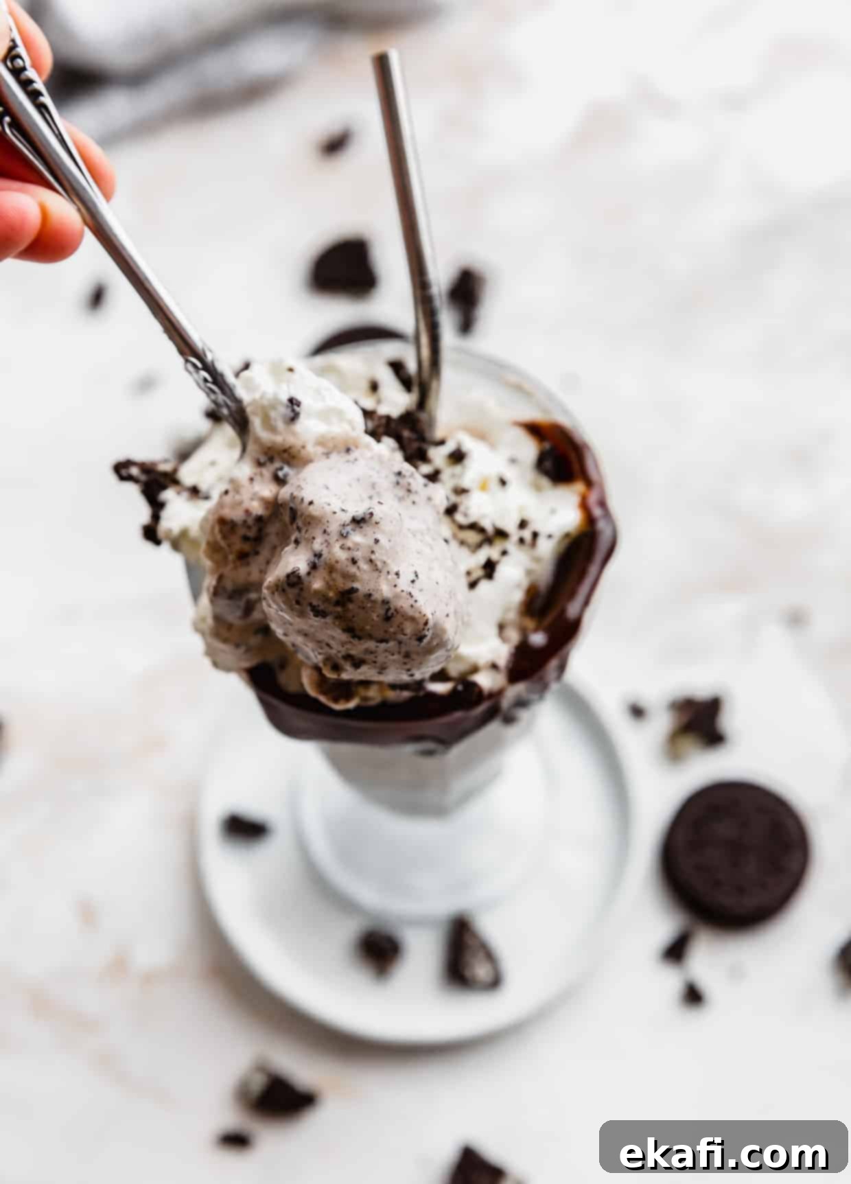 Ultimate Oreo Indulgence 7 A spoon scooping out homemade Oreo milkshake from a glass cup.