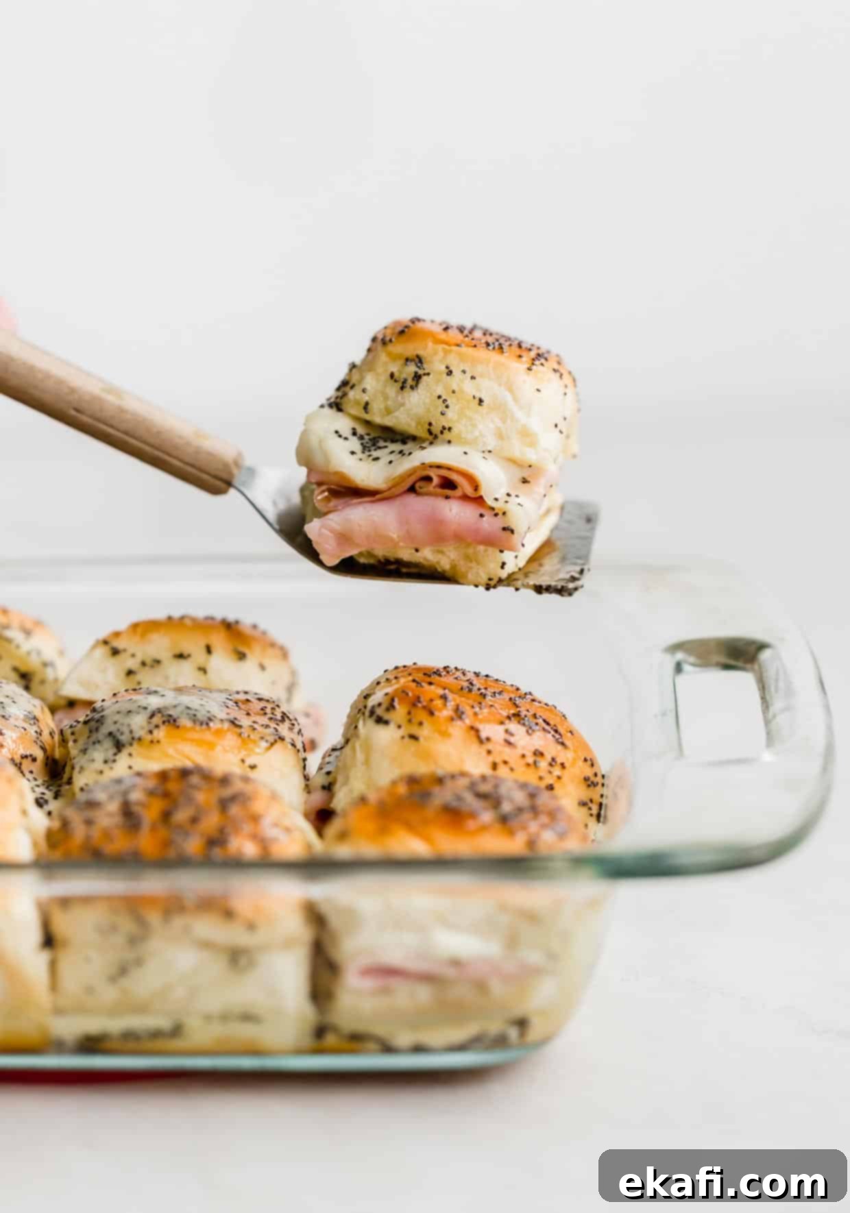 Gridiron Grub 15 A single Honey Mustard Ham and Cheese Slider on a metal spatula against a white background.