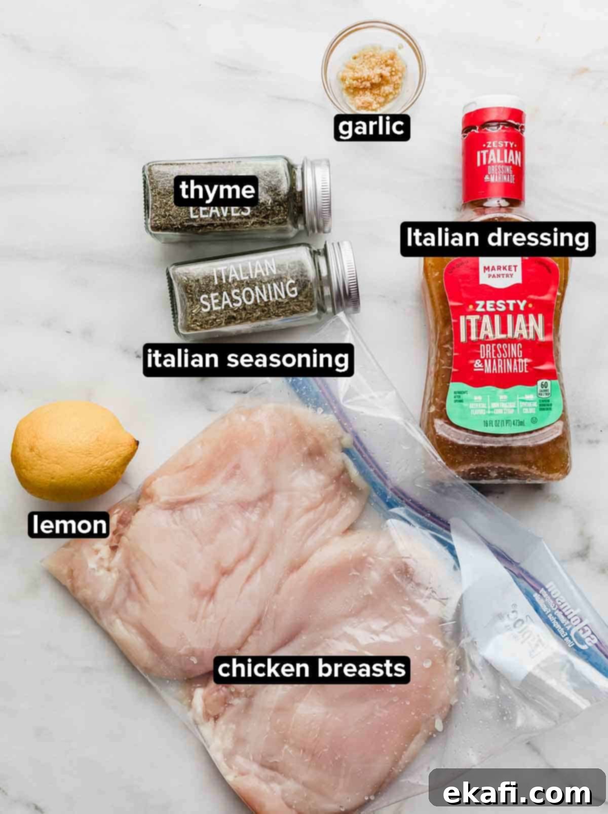 Zesty Italian Grilled Chicken 3 Italian Grilled Chicken ingredients on a white background: raw chicken breasts, lemon, Italian salad dressing, garlic, thyme and Italian seasoning.