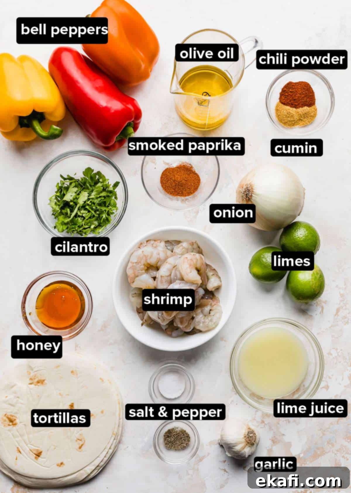 One-Pan Shrimp Fajitas 3 Sheet Pan Shrimp Fajitas ingredients portioned into glass bowls on a white background.