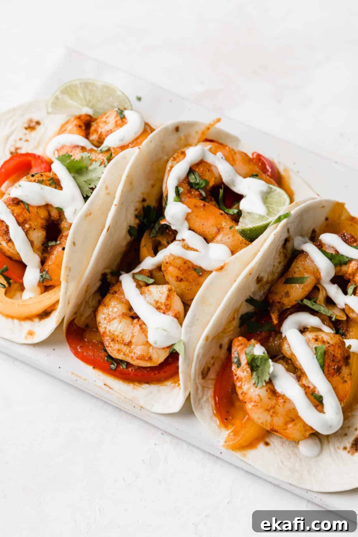 One-Pan Shrimp Fajitas 6 3 Shrimp fajitas with a drizzle of white Crema overtop.